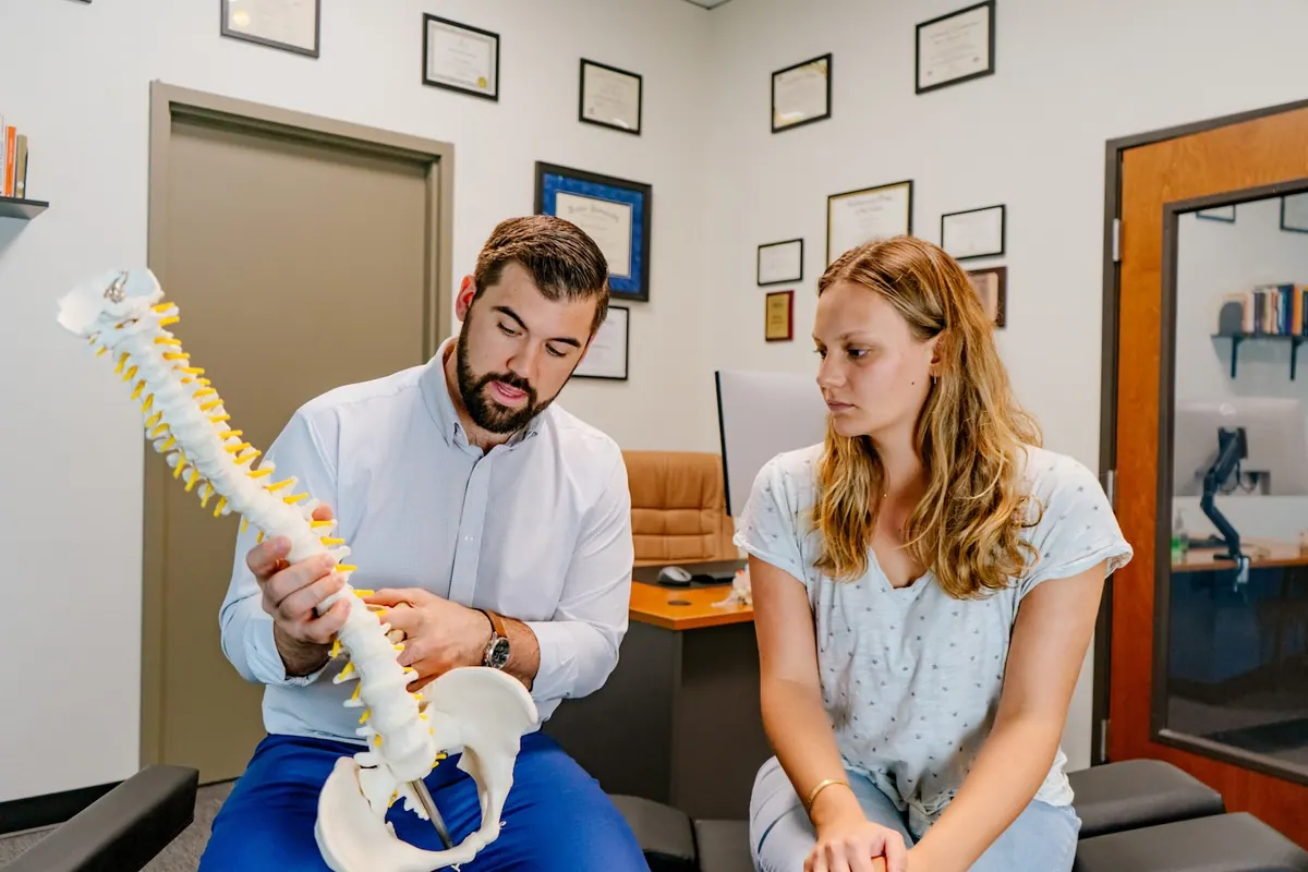 Chiropractor Explaining Spine Model to Patient