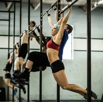 the people on the gym is doing pull ups