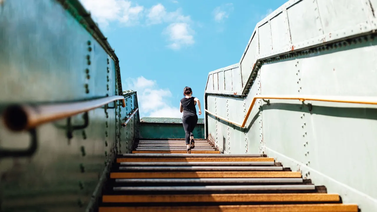 a woman jogging to a stairs