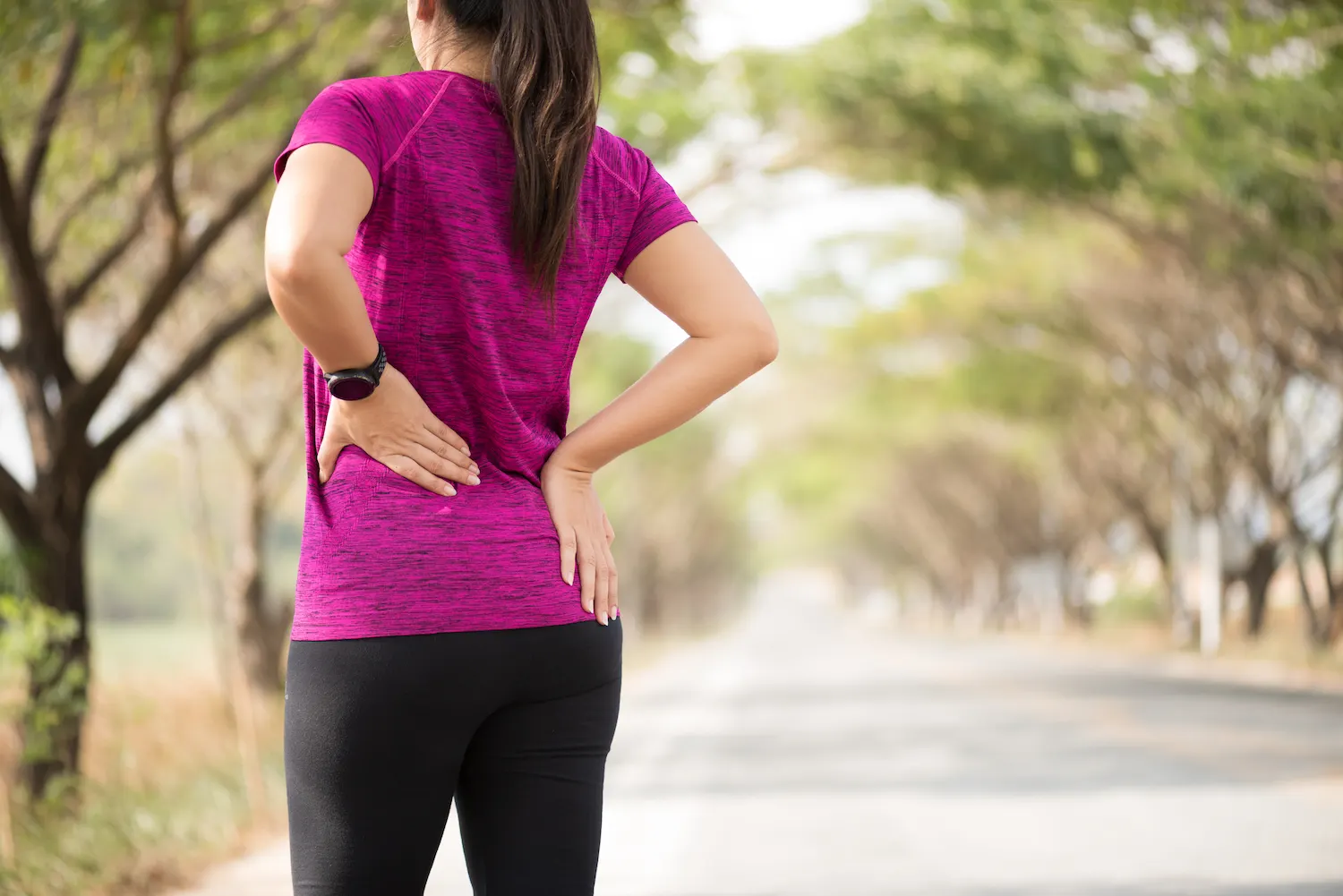 a woman having a back pain after a walk