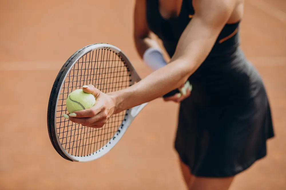 a woman playing a tennis with overuse injury